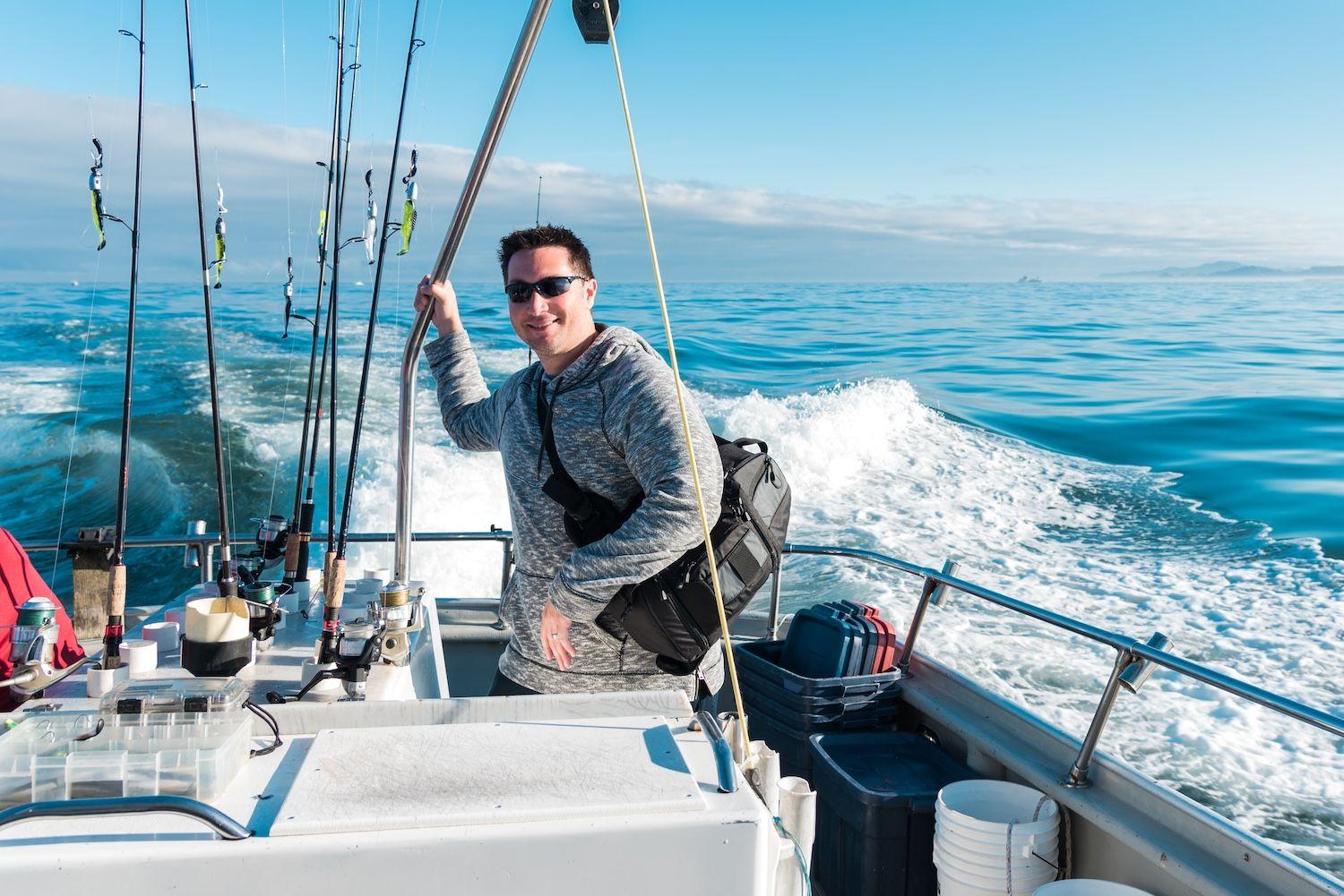 Man on boat next to fishing poles.